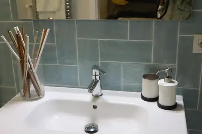 a bathroom sink with a toothbrush holder and a faucet at FOROPLAZA Porta San Pedro Pleno Centro Vistas Muralla in Lugo