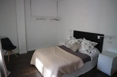 a bedroom with a bed and a lamp and a chair at FOROPLAZA Porta San Pedro Pleno Centro Vistas Muralla in Lugo