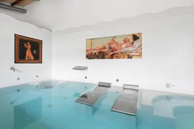 a large swimming pool with a painting on the wall at Áurea Palacio de Sober by Eurostars Hotel Company in Sober
