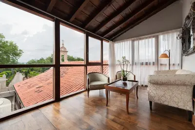 a living room with large windows and a couch and a table at Áurea Palacio de Sober by Eurostars Hotel Company in Sober