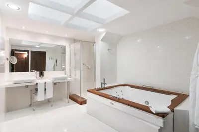 a bathroom with a tub and two sinks and a shower at Áurea Palacio de Sober by Eurostars Hotel Company in Sober