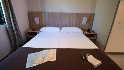 a hotel room with a bed with a map on it at Albergue Monte Do Gozo in Santiago de Compostela