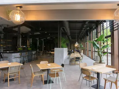 a restaurant with tables and chairs and windows at Albergue Monte Do Gozo in Santiago de Compostela