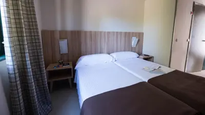 a hotel room with a bed and a window at Albergue Monte Do Gozo in Santiago de Compostela