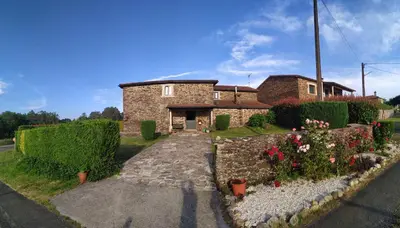 a brick house with flowers in front of it at Casa O Castelo en Touro in Touro