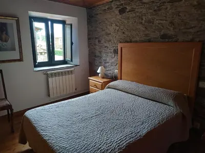 a bedroom with a bed and a window at Casa O Castelo en Touro in Touro
