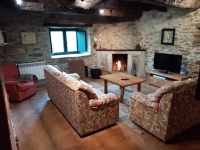 a living room with two couches and a fireplace at Casa O Castelo en Touro in Touro