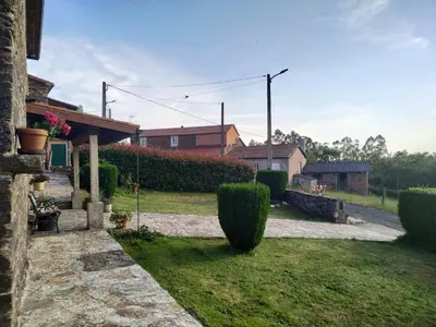 a house with a yard with bushes and a building at Casa O Castelo en Touro in Touro