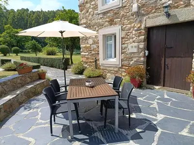 a table and chairs with an umbrella on a patio at Casa Valle in Foz
