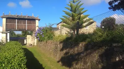 a house with a palm tree next to a wall at Casa Valle in Foz