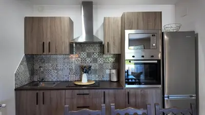 a kitchen with a sink and a microwave and a refrigerator at PANTON RURAL Casa Do José in Pantón