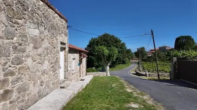 a stone wall next to a road at PANTON RURAL Casa Do José in Pantón
