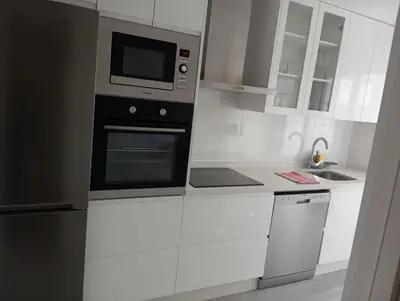 a white kitchen with a microwave and a refrigerator at PR Campanas de San Juan in Santiago de Compostela