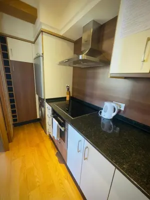 a kitchen with white cabinets and a black counter top at PR Campanas de San Juan in Santiago de Compostela