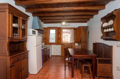 a kitchen with a table and a white refrigerator at Apartamentos Porcia in Tapia de Casariego