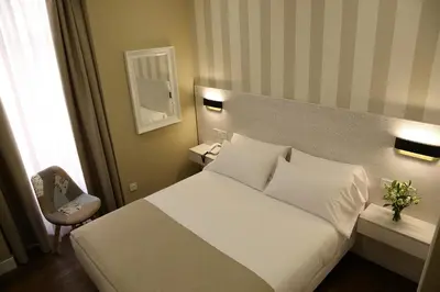 a hotel room with a white bed and a chair at VÍA XIX in Caldas de Reis