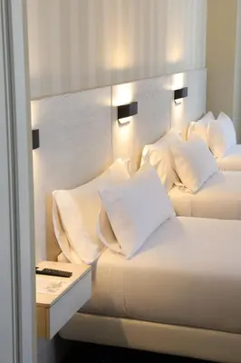 two beds with white sheets and pillows in a room at VÍA XIX in Caldas de Reis