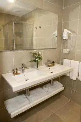 a bathroom with a sink and a mirror and towels at VÍA XIX in Caldas de Reis