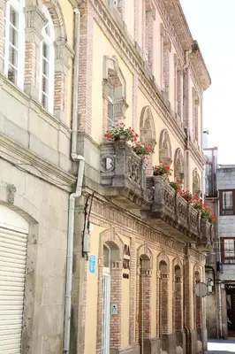 a building with flower boxes on the side of it at VÍA XIX in Caldas de Reis