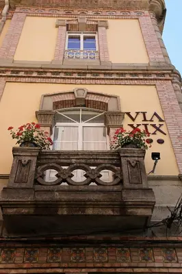 a building with a window with flowers on a balcony at VÍA XIX in Caldas de Reis