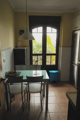 a kitchen with a table and chairs and a window at EDIFICIO CINE MON in Burela de Cabo