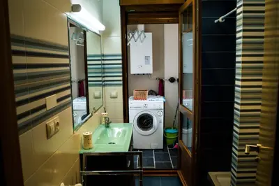 a bathroom with a washing machine and a washer at EDIFICIO CINE MON in Burela de Cabo