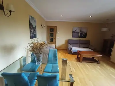 a living room with blue chairs and a couch at EDIFICIO CINE MON in Burela de Cabo