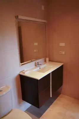 a bathroom with a sink and a mirror and a toilet at EDIFICIO CINE MON in Burela de Cabo