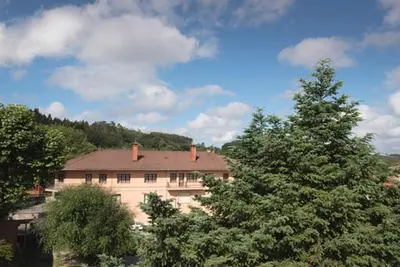 a large white house with trees in front of it at Pensión Dorotea in Lavacolla