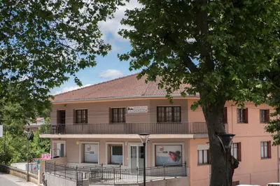 a pink building with a tree in front of it at Pensión Dorotea in Lavacolla