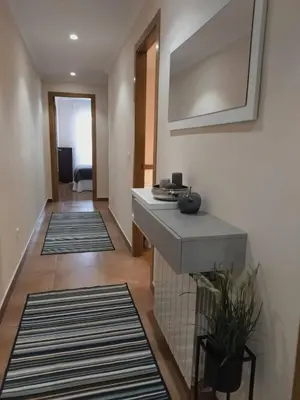 a hallway with a sink and some rugs at Ribadeo Centro in Ribadeo