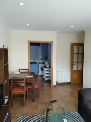 a living room with a table and a kitchen at Ribadeo Centro in Ribadeo