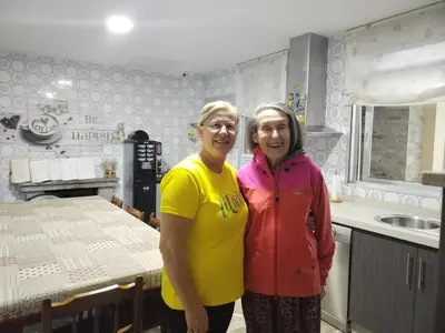 two women standing next to each other in a kitchen at Pensión Casa do Gallo Sarria in Sarria