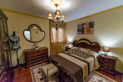 a bedroom with a bed and a dresser and a mirror at Apartamento Lemavos in Monforte de Lemos