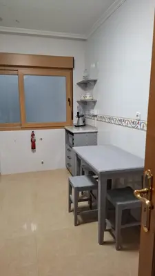 a kitchen with a table and two stools in it at nice apartment Don Santiago in Santiago de Compostela