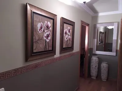 a hallway with three pictures of flowers on the wall at nice apartment Don Santiago in Santiago de Compostela