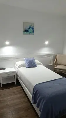 a bedroom with a bed with a blue pillow on it at La mesa del cocinero in Lugo