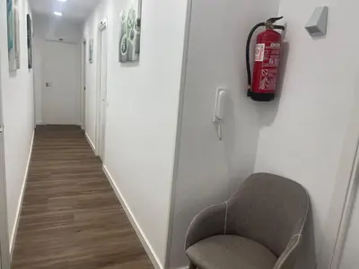 a hallway with a chair and a fire extinguisher at La mesa del cocinero in Lugo
