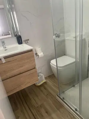 a bathroom with a toilet and a glass shower at La mesa del cocinero in Lugo
