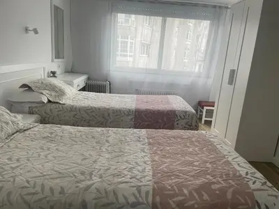 a hotel room with two beds and a window at La mesa del cocinero in Lugo