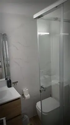 a bathroom with a toilet and a glass shower at La mesa del cocinero in Lugo