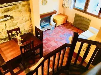 a living room with a table and a fireplace at Apartamentos Torre Villar in Villar de Vildas