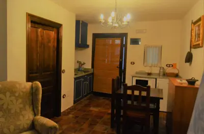 a kitchen with a door and a table and a chair at Apartamentos Torre Villar in Villar de Vildas