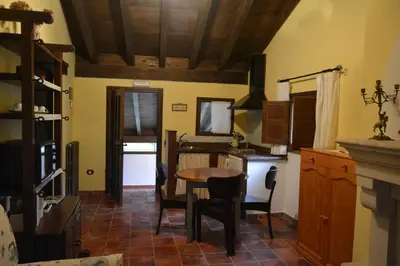a kitchen with a table and chairs in a room at Apartamentos Torre Villar in Villar de Vildas