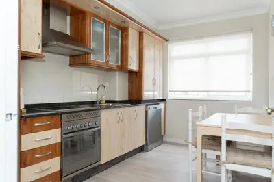 a kitchen with wooden cabinets and a stove top oven at AMPLIO APARTAMENTO EN BURELA in Burela de Cabo