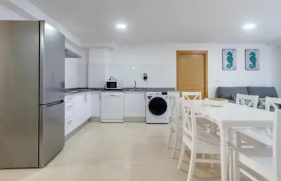 a kitchen with a table and a refrigerator at Duerming Family Viveiro 4 Rooms in Viveiro