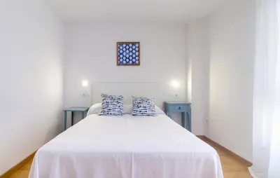 a bedroom with a white bed with two blue tables at Duerming Family Viveiro 4 Rooms in Viveiro