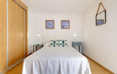 a bedroom with a white bed and two blue tables at Duerming Family Viveiro 4 Rooms in Viveiro