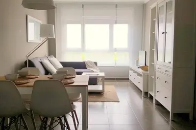 a living room with a table and a couch at Apartamento con piscina en Foz in Foz