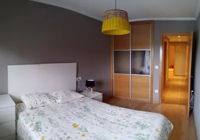 a bedroom with a bed and a pendant light at Apartamento con piscina en Foz in Foz